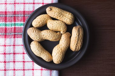 Tabakta fıstık ve eski mutfak bezi. Kahverengi doğal masa. Düz manzaralı. Vejetaryen gıda konsepti.