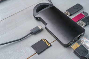 USB tip C adaptörü veya çeşitli aksesuarları olan merkez - kalem sürücüleri, hdmi, ethernet, hafıza kartı, kablolar. Uzayı sola kopyala.
