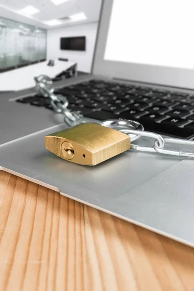 Padlock and chain with laptop computer in a presentation board office room. Cyber security abstract concept.