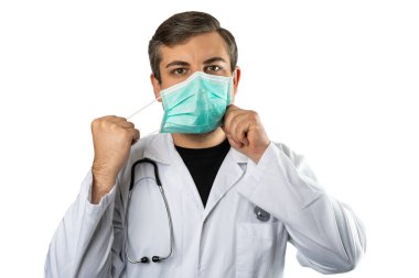 Beyaz önlüklü beyaz doktor kılığına girmiş beyaz bir adam ya da koruyucu maskeyi çıkarırken boynuna steteskop takmış bir adam. Beyaz arkaplanda izole.