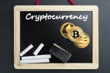 Fiziksel Bitcoin, Litecoin ve Ethereum altın sikkeleri tebeşirle yazılmış bir tahtanın üzerinde. Kripto para birimi eğitimi soyut bir kavram.