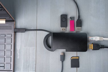 USB tip C adaptör ya da çeşitli aksesuarlarla bilgisayara bağlı merkez - kalem sürücüleri, hdmi, ethernet, hafıza kartı, kablolar. Düz üst görünüm.