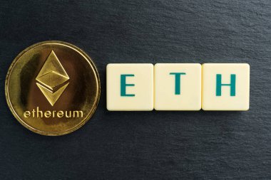 Harf karolarından yapılmış yazılı fiziksel Ethereum altın sikkesi. Kripto para birimi.