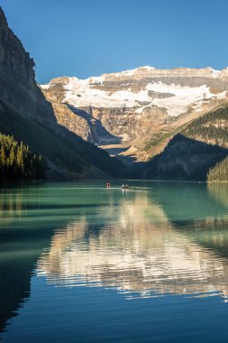 Muhteşem göl çevrili dağlar ve buzullar, turist kayık bir mavi gökyüzü günde Banff National Park Kanada'da yapıyor.