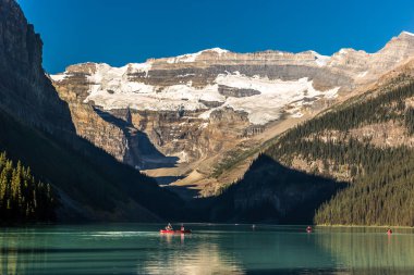 Dağlar ve buzullar, kayık Banff National Park Kanada'da bir mavi gökyüzü gün yapıyor turistler tarafından çevrili yeşil göl