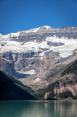 Muhteşem göl çevrili dağlar ve buzullar, turist kayık bir mavi gökyüzü günde Banff National Park Kanada'da yapıyor.