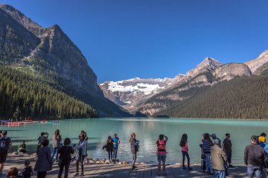 Banff, Kanada - önce 14 2017 - turist Gölü buzultaş önünde sabahın erken saatlerinde grup. Mavi gökyüzü, arka plan dağlarda, ağaçlarda Banff Kanada tonları.