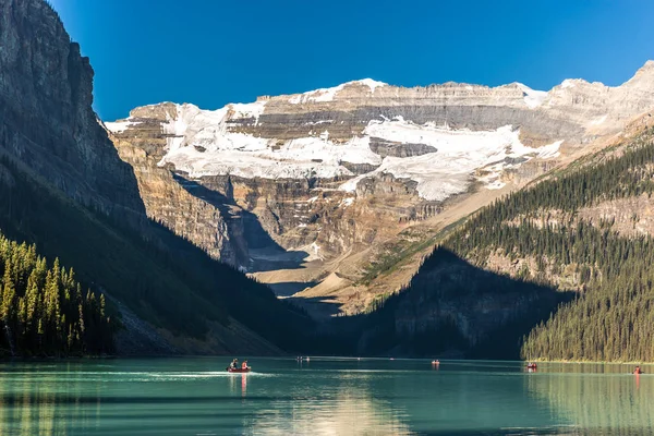 Muhteşem göl çevrili dağlar ve buzullar, turist kayık bir mavi gökyüzü günde Banff National Park Kanada'da yapıyor.