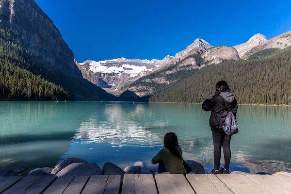 Banff, Kanada - önce 14 2017 - turist Gölü buzultaş önünde sabahın erken saatlerinde grup. Mavi gökyüzü, arka plan dağlarda, ağaçlarda Banff Kanada tonları.