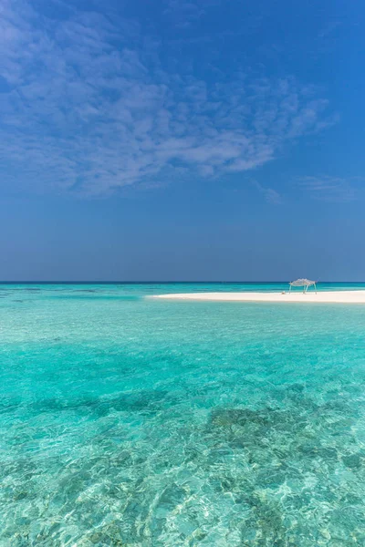 Amazing blue water in a desert island, blue sky day, wood hut