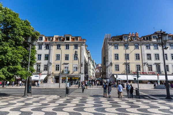 Lisbon, Portugal - May 9th 2018 - Tourists and locals walking in a traditional boulevard in Lisbon downtown in a blue sky day, Portugal.