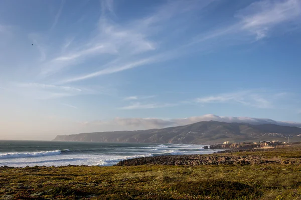 Amazing landscape scenario at the Guincho beach in Cascais, Portugal. Sunset colors, mountains, big waves.