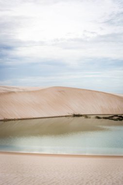 Beyaz kum tepeleri ile doğal havuzu lagün ortasında, şaşırtıcı bulutlu gün. Su yansıma.
