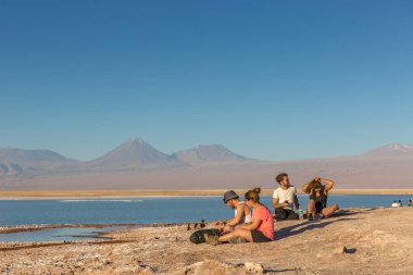 Atacama an, arka plan, Şili Andes Dağları aralığında rahatlatıcı Salar, önünde oturan Atacama, Chile - 9th Ekim 2017 - Genç çiftler.