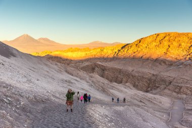 Atacama Çölü - 9 2017 - dışarı ay Valle (Vale de la Luna) tepeleri ile ikindi, yürüyen turist günbatımı renkleri ve Şili gölgeler