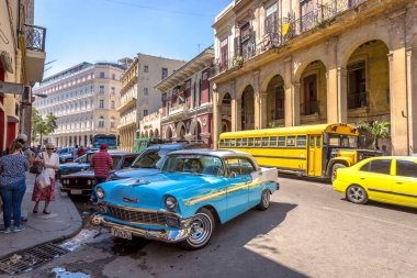 Havana, Küba - 11th Mart 2018 - mavi Havana, otobüs ve taksi sömürge binaları arka planda bir sokakta canlı eski araba.