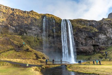 Seljalandsfoss, İzlanda - 22 Ekim 2017 - turist bir bulutlu gün Seljalandsfoss sonbaharda İzlanda'zevk.