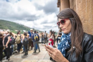 Ouro Preto'daki, Minas Gerais - 2 Kasım 2018 - genç kadın Ouro Preto'daki, Brezilya ona yakın turist bir grup ile bir telefon kullanma