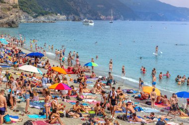 Cinque Terra, İtalya - 18th Mayıs 2018 - büyük grup insan Cinque Terra, stand-up kürek yapıyor ve İtalya'da yüzme insanlar plajda eğlenmek