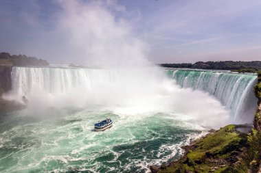 Çok yakın bir su düşüş geçen Niagara Falls Kanada'da bir mavi gökyüzü gün turistik bir tekne