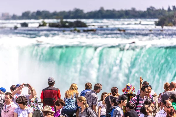 Niagara, Ago 20th 2017 - Big group of people in the foreground looking to the Niagara Falls in a summer hot day in Canada