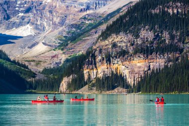 Banff, Canada - 2017 10 Eylül - turistler, rocky Dağları ve çam ağaçları içinde belgili tanımlık geçmiş Banff, Kanada ile Lake Louise kayık yapıyor