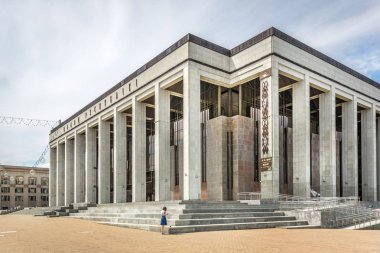 Minsk, Beyaz Rusya - 28th Temmuz 2018 - A büyük beton Minsk, Beyaz Rusya önündeki bir kadınla çok düz çizgileri olan bina