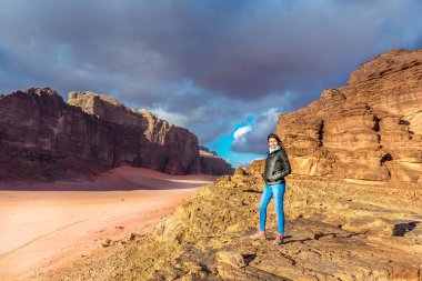 Wadi Rum, Ürdün - 17th Şubat 2018 - A genç kadın geç bir gün batımı Wadi Rum çölde Ürdün eğleniyor