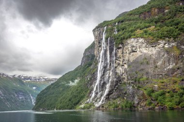 Norveç fiyortları bulutlu yağmurlu gün ortasında bir şelale