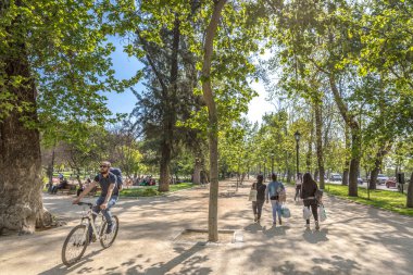 Santiago, Şili - 1st Ekim 2017 - A guy bir bisiklet ve bir grup insan Santiago del Chile, Chile başkenti bir açık hava genel parkta yürüyüş