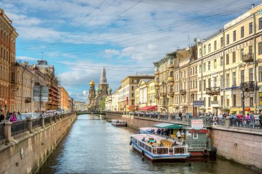 Saint Petersburg, Rusya Federasyonu - 8th Haziran 2018 - büyük grup arka planda büyük bir kilise ve yaz aylarında geleneksel binalar ile bir kanalınkıyısında yürüyen turist Rusya'da gün temizleyin