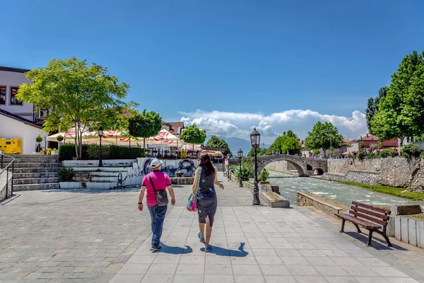 2018年5月30日 科索沃普里兹伦 一对夫妇走在一条河边 背景是一座石桥 餐馆和树木 — 图库照片
