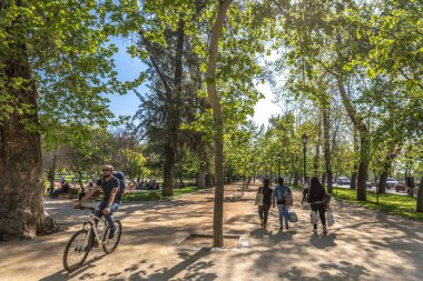 Santiago, Şili - 1st Ekim 2017 - A guy bir bisiklet ve bir grup insan Santiago del Chile, Chile başkenti bir açık hava genel parkta yürüyüş