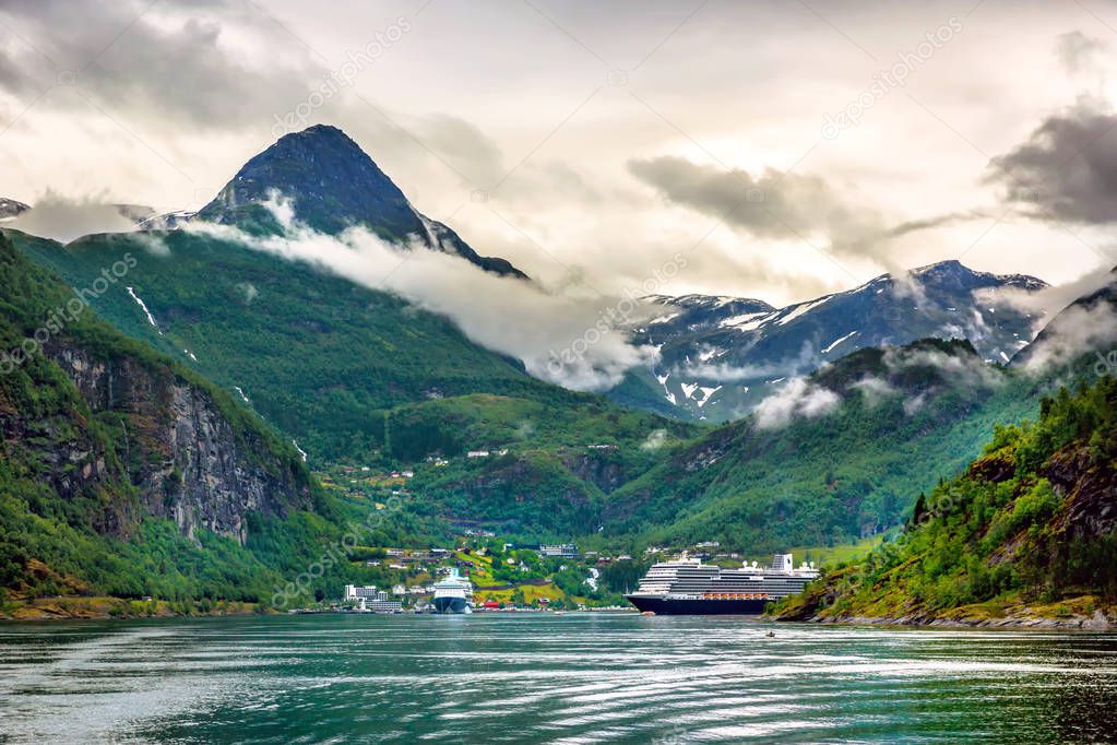 Huge cruiser in the middle of the fjords with high peak mountain in Norway