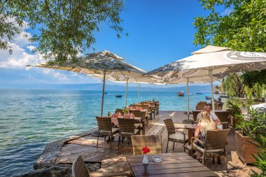 Ohrid, Makedonya - 1 Haziran 2018 - çift Ohri Gölü ile inanılmaz bir senaryoda bir mavi gökyüzü günde Makedonya'da yemek