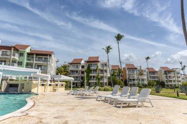 Mavi gökyüzü gün Punta Cana, Dominik Cumhuriyeti için büyük bir yüzme havuzu ile bir plaj ön kapı topluluk