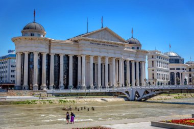 Skopje, Makedonya - 2nd Temmuz 2018 - iki kadın nehir ve büyük devlet Makedonya Üsküp'bina önünde