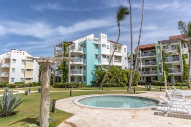 Mavi gökyüzü gün Punta Cana, Dominik Cumhuriyeti için büyük bir yüzme havuzu ile bir plaj ön kapı topluluk