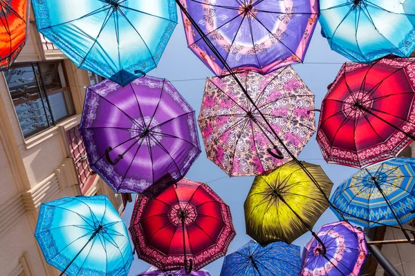 Colorful umbrellas in a city with blue sky