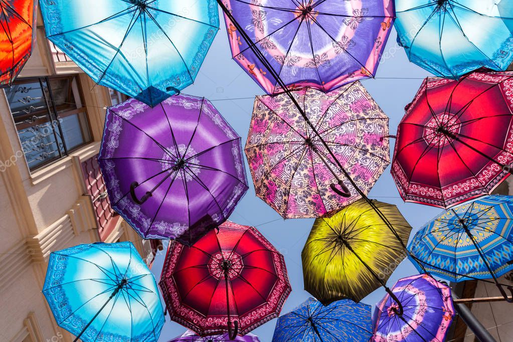 Colorful umbrellas in a city with blue sky