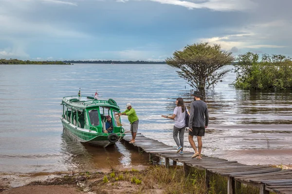 4 april 2018 - Amazonewoud, Brazilië - Toeristen wandelen in een rustieke pier om een boot te betreden in de Amazone rivier in Noord Brazilië — Stockfoto