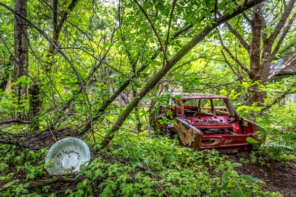 Заброшенная красная русская старая машина, окруженная лесом в Чернобыле на Украине — стоковое фото
