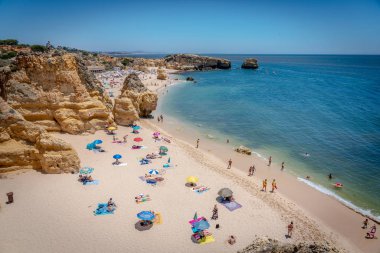 28 Haziran 2019 - Algarve, Portekiz - Güney Portekiz, Algarve 'de mavi gökyüzünde Sao Rafael' in muhteşem plajının tadını çıkaran turistler ve yerliler