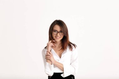 Gözlüklü mutlu bir kadın beyaz arka plandan kameraya bakıyor. Güzel gülüşü olan güzel bir kadın en iyi gözlüklerini gösteriyor..