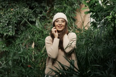 Yeşil Park 'taki giyim mağazası için modaya uygun bir model. Kış bahçesinde harika bir gülümsemesi olan mutlu bir kız. CENNET HAYATTI GELİYOR.