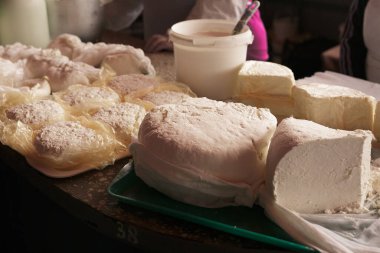 Masanın üzerinde sütlü ev yapımı süzme peynir.