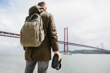 Adam sanal gerçeklik gözlük tutan ve 25 Nisan köprü Lizbon'bakar. Sanal seyahat ve Turizm kavramı. Modern teknolojiler ve bunların kullanımı günlük yaşamda