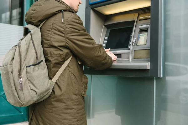 De toerist trekt geld uit de geldautomaat voor verdere reizen. Grijpt een kaart uit de Atm. Finance, de creditcard, de terugtrekking van geld. — Stockfoto