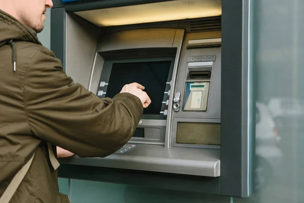 De toerist trekt geld uit de geldautomaat voor verdere reizen. Financiën, creditcard, terugtrekking van geld. — Stockfoto