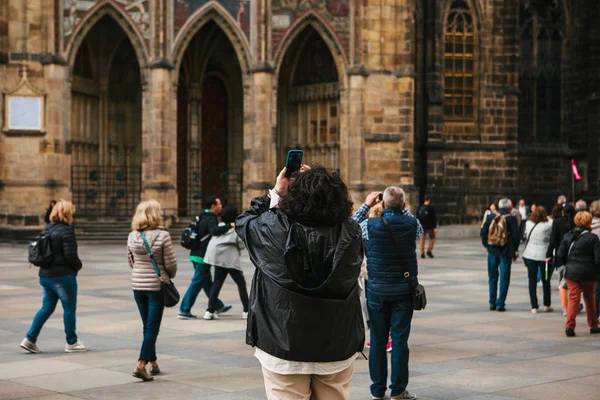 Туристы фотографируют достопримечательности Праги в Чехии. Впереди красивая архитектура — стоковое фото